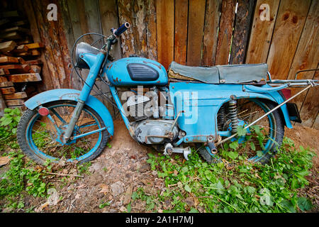 Un vieux stand moto abandonnée près d'une clôture dans le village. Banque D'Images