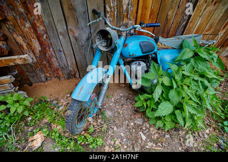 Un vieux stand moto abandonnée près d'une clôture dans le village. Banque D'Images