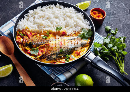 Poisson au Curry jaune, curry Panang avec Saba maquereau grillé poisson servi avec riz long grain cuit à la vapeur dans une poêle sur une table, une vue d'abo Banque D'Images