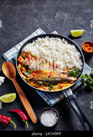 Poisson au Curry jaune, curry Panang avec Saba maquereau grillé poisson servi avec riz long grain cuit à la vapeur dans une poêle sur une table, vue verticale Banque D'Images