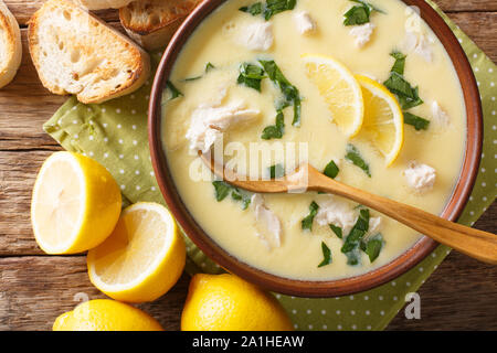 Soupe Fraîche de citron grec avec du poulet et de l'orzo coller close-up dans un bol sur la table. Haut horizontale Vue de dessus Banque D'Images