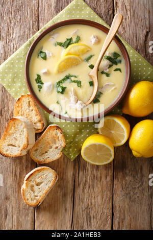 Oeuf maison soupe poulet et citron avec orzo de close-up dans un bol sur la table. Haut Vertical Vue de dessus Banque D'Images