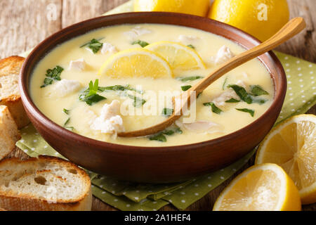 Soupe de citron grec aromatiques épais avec du poulet et de l'orzo coller close-up dans un bol sur la table horizontale. Banque D'Images