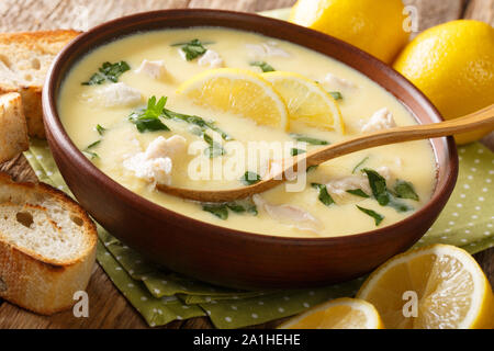 Soupe Fraîche de citron grec avec du poulet et de l'orzo coller close-up dans un bol sur la table horizontale. Banque D'Images