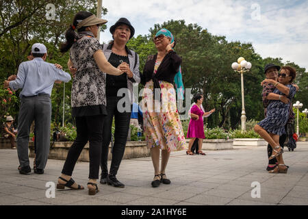 Les femmes vietnamiennes d'âge moyen danser dans le parc, Ho Chi Minh City, Vietnam Banque D'Images