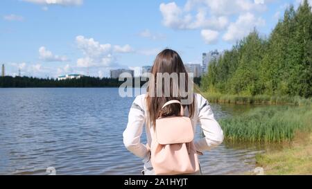 Fille brune avec un sac à dos offre une vue panoramique. Lac et paysage magnifique. L'aventure, la liberté, le mode de vie Banque D'Images