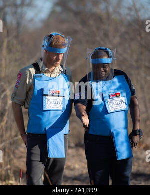 Le duc de Sussex et Halo Gestionnaire régional Jose Antonio à pied à travers un champ de mines dans la région de Dirico, en Angola, au cours d'une visite pour voir le travail de déminage la charité le Halo Trust, sur cinq jours de la tournée royale de l'Afrique. Banque D'Images