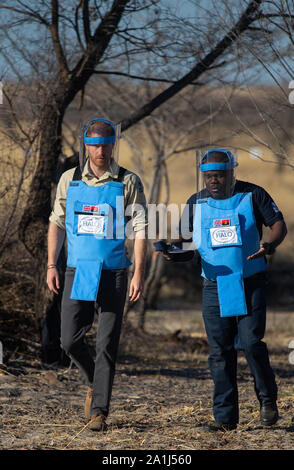 Le duc de Sussex et Halo Gestionnaire régional Jose Antonio à pied à travers un champ de mines dans la région de Dirico, en Angola, au cours d'une visite pour voir le travail de déminage la charité le Halo Trust, sur cinq jours de la tournée royale de l'Afrique. Banque D'Images