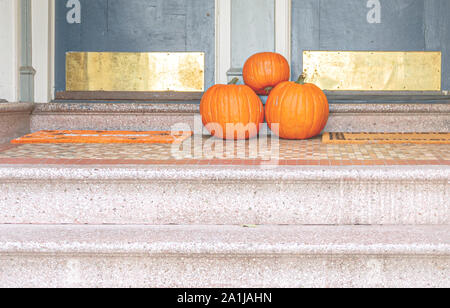 Trois citrouilles à la fin d'un escalier d'une maison d'habitation. Décorations d'Halloween Banque D'Images