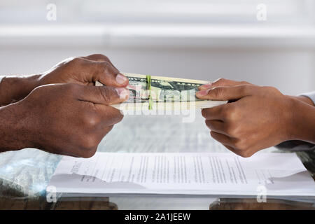 Deux mains tenant plus de l'entente de divorce Monnaie Banque D'Images