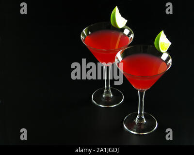 Deux cocktails sans alcool Bacardi rouge vif fait de rhum blanc, le jus de lime et de grenadine, en verres à cocktail conique, décoré de tranches de lime Banque D'Images