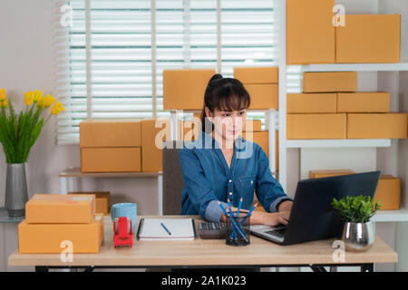 Charmante belle asiatique propriétaire adolescent femme d'affaires travailler à la maison pour faire des achats en ligne, à l'ordre dans un ordinateur portable avec l'équipement de bureau, entreprene Banque D'Images