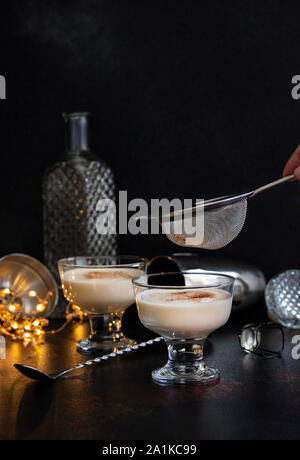 Noël traditionnel verre de lait de poule à la cannelle et la muscade dans deux verres sur une table avec des outils et de la barre de décorations de Noël. Sprinki Banque D'Images