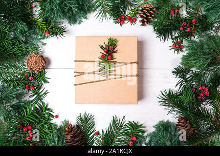 Boîte cadeau de Noël et de branches de sapins sur blanc. Banque D'Images