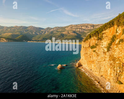 Vue aérienne de Buljarica promontoire, falaise abrupte sur la côte baignée par des eaux cristallines de la mer Adriatique. Petrovac. Monténégro Banque D'Images