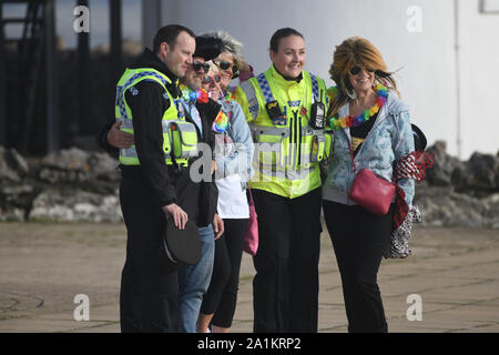 Porthcawl, Pays de Galles, Royaume-Uni. Vendredi 27 avril, 2019 septembre. Les gens en photo arrivant à Porthcawl en Galles du Sud ont leur photo prise avec des agents de police au début du Festival Elvis annuel. Dans le cadre de cette compétition, des milliers de personnes descendent sur la ville balnéaire de prendre part au plus grand Festival Elvis de son genre en Europe, pour célébrer la vie et de la musique du roi. Il y a plus de 100 spectacles et événements à travers 20 endroits autour de la ville, notamment des spectacles et des concours de costumes. Crédit photo : Robert Melen/Alamy Live News Banque D'Images