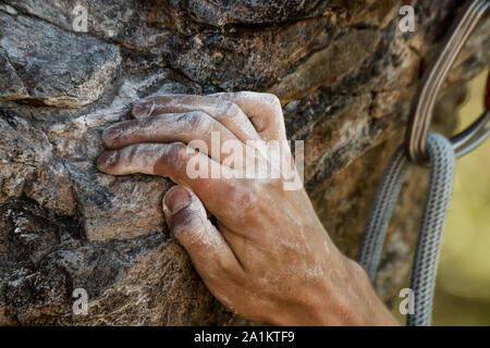 Vue rapprochée du rock Climber's main agrippant tenir sur falaise naturelle. Banque D'Images