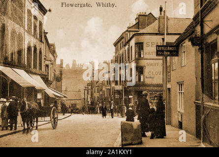 C1900- Une vieille carte postale montrant Flowergate, Whitby, North Yorkshire, UK à l'époque. Le petit ange pub est vu à la droite. De l'autre côté de la route est la boutique de gentlemans Outfitters Spanton's, et dans la distance peut être vu l'abbaye de Whitby. (Tous sont toujours là). Le bloc de montage de cheval en pierre (avant droit) est toujours en place mais a été gravement endommagé par la circulation moderne. L'Abbaye Inn en premier plan, joint à la Little Angel est maintenant (en 2019) une succursale des Yorkshire Building Society. Banque D'Images