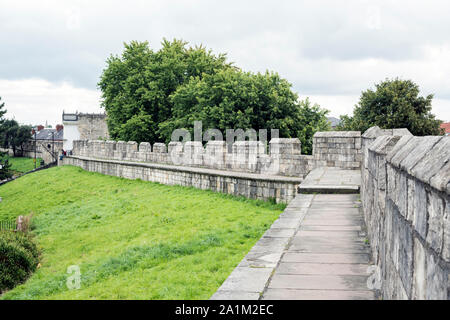 Aspect du mur romain de la ville de York, au Royaume-Uni avec des arbustes et de pelouses point contre ciel nuageux. Banque D'Images