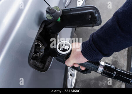 Main tenant la buse diesel de voitures de ravitaillement à la station de gaz. La pompe à carburant Banque D'Images