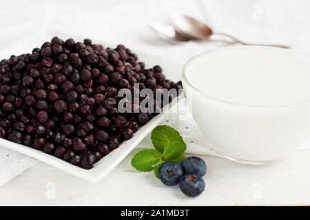 Bleuets congelés et le lait de coco. Ingrédients pour frappé aux bleuets Banque D'Images