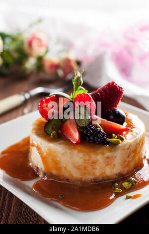 Cheesecake végétalien premières avec sirop de caramel et de baies fraîches Banque D'Images