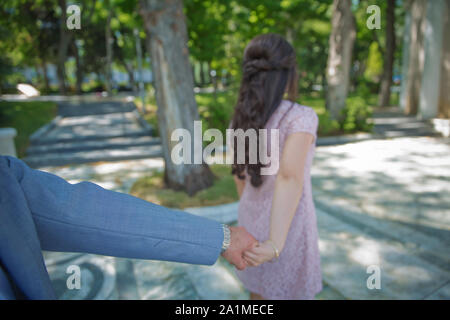 La jeune fille tenir la main Garçon Fille Garçon .tire la main .Young happy girl tire le gars part Banque D'Images