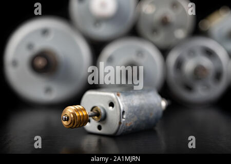 Petits moteurs électriques sur un comptoir. Accessoires électriques sur une table de l'atelier. Fond sombre. Banque D'Images