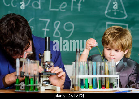 L'exemple personnel et d'inspiration. L'activité d'enseignement de l'étude par l'expérience. J'aime étudier dans l'école. Enseignant et garçon en laboratoire de chimie. Étudier la chimie et la biologie. L'étude est intéressante. Banque D'Images