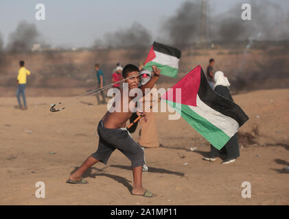 La bande de Gaza. 27 Sep, 2019. Un manifestant palestinien utilise une fronde pour lancer des pierres sur des soldats israéliens lors d'affrontements sur la frontière Gaza-Israel, à l'est du sud de la bande de Gaza ville de Khan Younis, 27 septembre 2019. Un jeune Palestinien a été tué vendredi par des tirs de l'armée israélienne au cours de l'hebdomadaire des manifestations anti-Israël le long de la frontière Gaza-Israel, ministère de la santé palestinien à Gaza a dit. Au moins 63 Palestiniens ont été blessés au cours d'une journée de protestation dans l'est de Gaza, Ashraf al-Qedra, porte-parole du ministère de la santé à Gaza, a dit. Credit : Yasser Qudih/Xinhua/Alamy Live News Banque D'Images