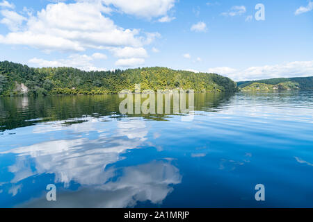 Bord du lac reflète et les nuages blancs sur l'idyllique Lac Rotoiti près de Rotorua Nouvelle Zélande. Banque D'Images