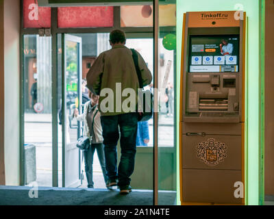 Moscou, Russie - le 14 septembre 2019 : un homme en passant par la borne jaune avec le logo Banque Tinkoff. Distributeur automatique de billets à l'entrée du centre commercial. Les visiteurs à la porte Banque D'Images