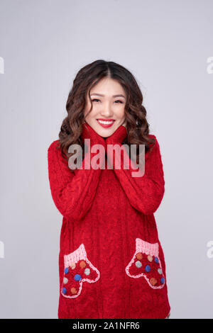 Portrait d'hiver beauté fille asiatique en rouge robe en laine tricoté. Vacances de Noël. Banque D'Images