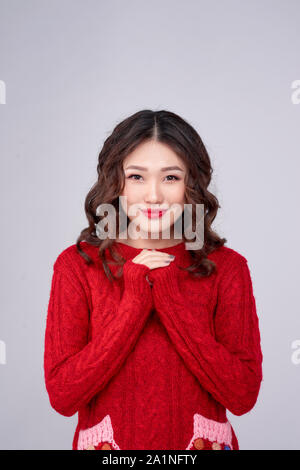 Portrait d'hiver beauté fille asiatique en rouge robe en laine tricoté. Vacances de Noël. Banque D'Images