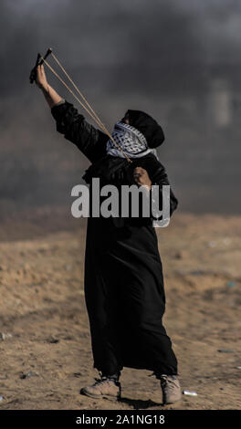 Gaza, la Palestine. 27 Sep, 2019. Un manifestant palestinien utilise une fronde pour lancer des pierres au cours d'une manifestation exigeant la fin de l'asphyxie siège sur la bande de Gaza pendant des années à la frontière Israel-Gaza clôture dans le sud de la bande de Gaza. Credit : SOPA/Alamy Images Limited Live News Banque D'Images