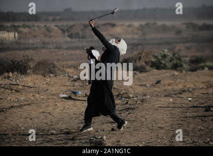 Gaza, la Palestine. 27 Sep, 2019. Un manifestant palestinien utilise une fronde pour lancer des pierres au cours d'une manifestation exigeant la fin de l'asphyxie siège sur la bande de Gaza pendant des années à la frontière Israel-Gaza clôture dans le sud de la bande de Gaza. Credit : SOPA/Alamy Images Limited Live News Banque D'Images