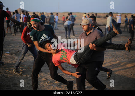 Gaza, la Palestine. 27 Sep, 2019. Des manifestants palestiniens transporter une personne blessée lors d'une manifestation demandant la levée de l'asphyxie siège sur la bande de Gaza pendant des années à la frontière entre Israël et la bande de Gaza dans le sud de la bande de Gaza. Credit : SOPA/Alamy Images Limited Live News Banque D'Images