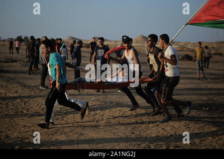 Gaza, la Palestine. 27 Sep, 2019. Des manifestants palestiniens transporter une personne blessée lors d'une manifestation demandant la levée de l'asphyxie siège sur la bande de Gaza pendant des années à la frontière entre Israël et la bande de Gaza dans le sud de la bande de Gaza. Credit : SOPA/Alamy Images Limited Live News Banque D'Images