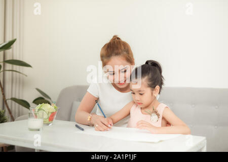 La famille asiatique avec la mère et les filles sont dessin sur le papier à la maison. Banque D'Images