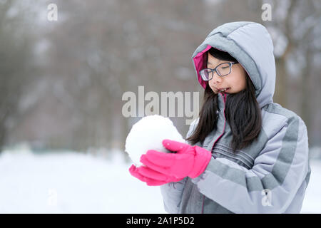 Portrait of Asian teen tenant une boule de neige en mains Banque D'Images