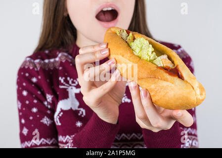 Si délicieux repas appétissants lave concept. Portrait la photo en gros plan de l'adolescent délicieux satisfaits commencent manger essayer de mordre gros iso sandwich Banque D'Images