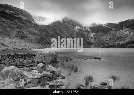 Superbe paysage d'hiver spectaculaire image de Llyn Idwal et sommets de montagnes de Snowdonia en Glyders en noir et blanc Banque D'Images