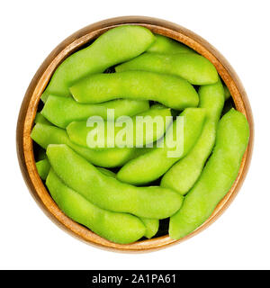 Edamame, soja vert dans le pod, dans bol en bois. Les graines de soja immatures, aussi Maodou. Glycine max, une légumineuse, comestibles après cuisson. Source de protéines. Banque D'Images