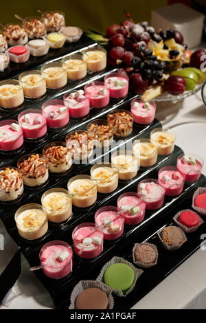 Divers desserts en verres sur table de restaurant - crème brûlée et le panna cotta Banque D'Images