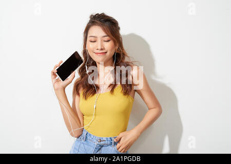 Portrait d'une belle jeune fille enjouée holding mobile phone isolé sur fond blanc Banque D'Images