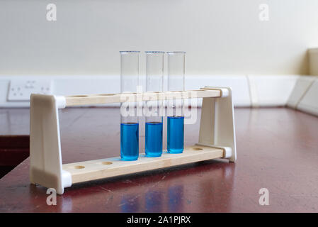 Sol en bois porte-tubes à essai avec tube à essai de la solution de sulfate de cuivre dans une ancienne école laboratoire de sciences. L'éducation scientifique lab concept Banque D'Images