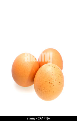 Trois oeufs brun isolé sur la surface blanche en orientation portrait Banque D'Images