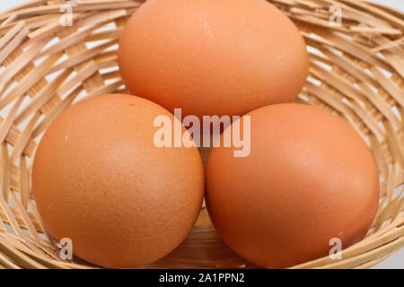 Vue rapprochée de trois oeufs dans le panier en rotin Banque D'Images