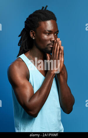 L'homme conserve l'afro grave paumes ensemble réfléchir aux problèmes, il souhaite le bonheur, la santé pour sa famille et ses amis, foi concept , close up side v Banque D'Images