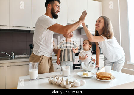 Happy happy couple positif élevé donnant à chacun des cinq autres, des succès à célébrer pendant la cuisson dans la cuisine. le bonheur, sentiment positif et emoti Banque D'Images